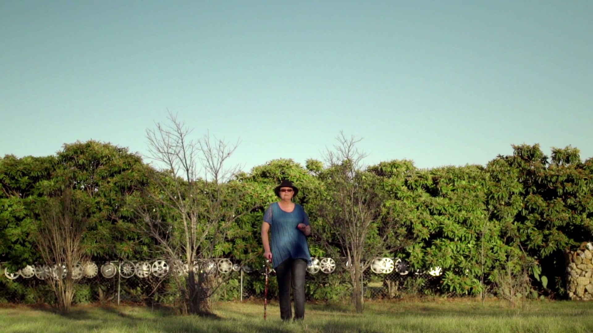Erin stands outdoors in a familiar setting from the Covered documentary.