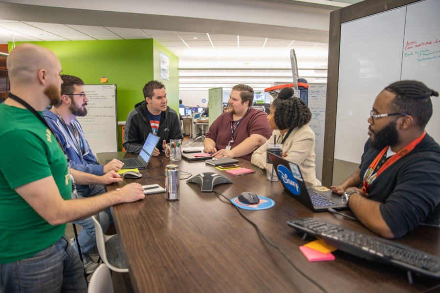 Quicken Loans colleagues gathered around a table with laptops and notebooks.