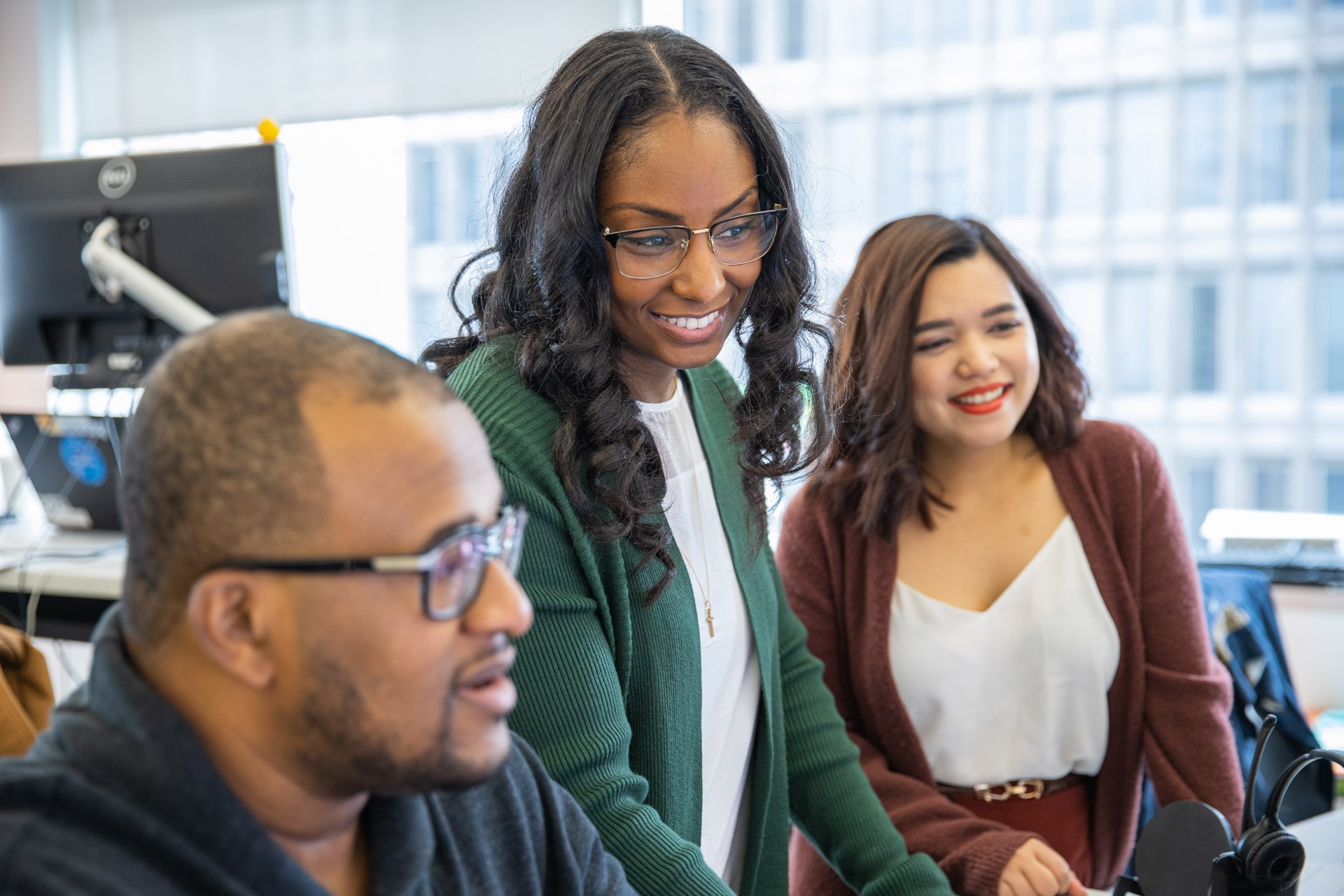 Three Quicken Loans colleagues sharing a workstation.